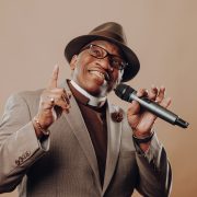 John Lee Hooker Jr. looking up in a brown suit.